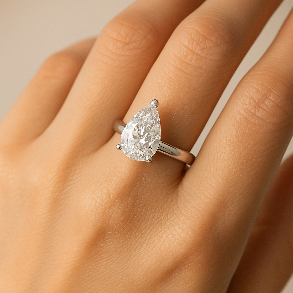 Pear cut moissanite diamond ring on model’s hand showing elegant sparkle